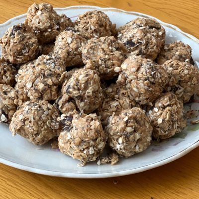 Protein bites on a white plate sitting on a table.