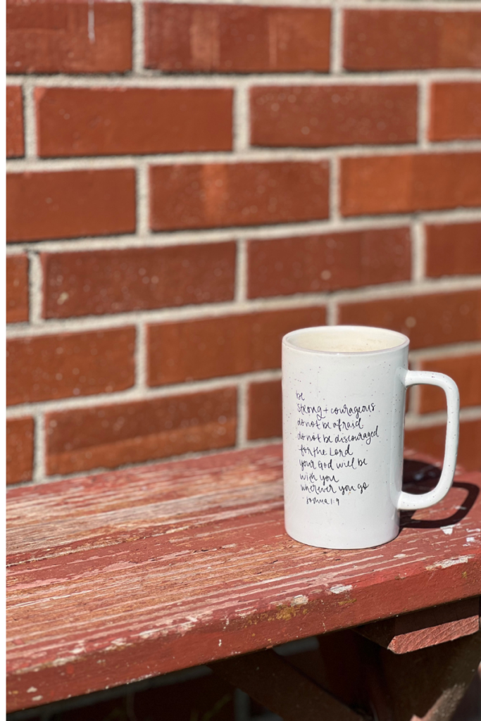 coffee cup sitting on a bench with a brick wall background