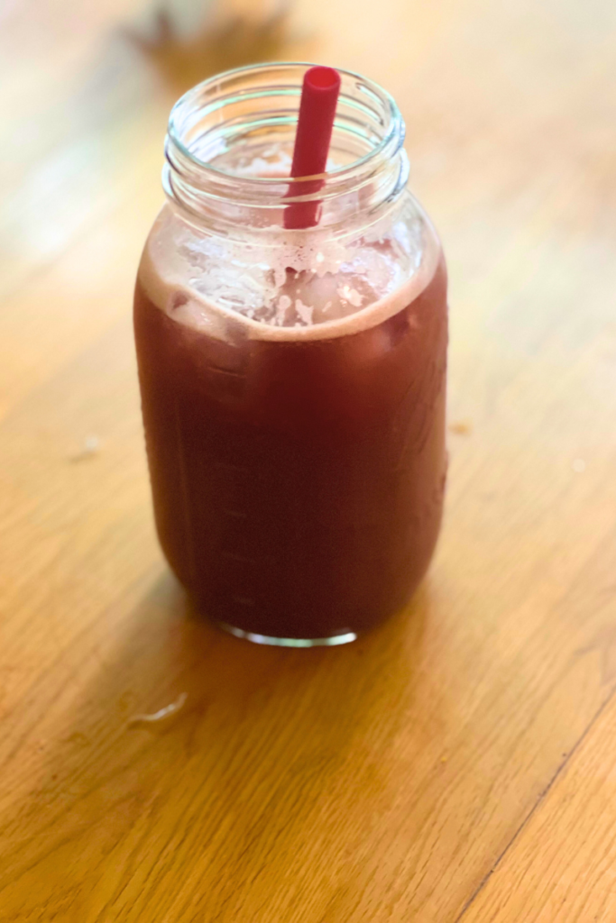 Red drink in a mason jar with a straw